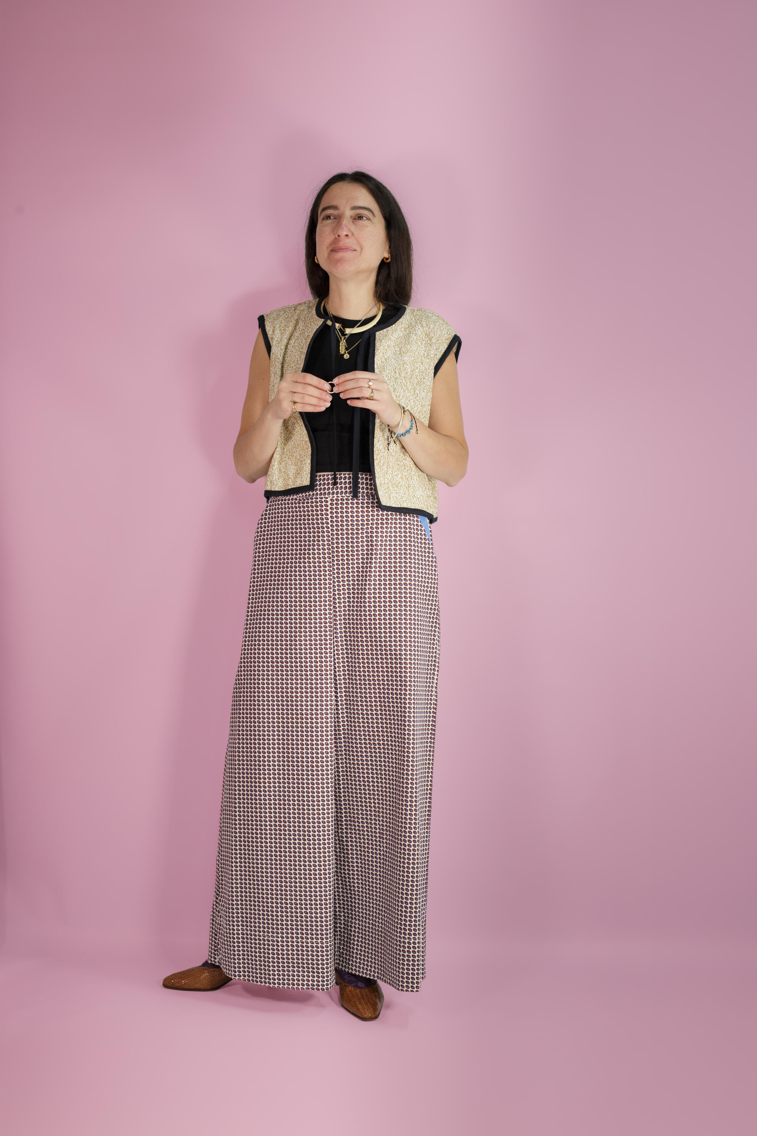 Alina Stanila, British fashion designer and founder of Mystic Moods, photographed standing against a pink studio background in 2026.